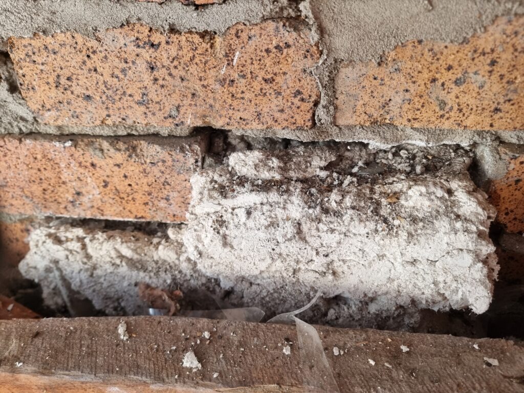 Asbestos insulation between bricks.