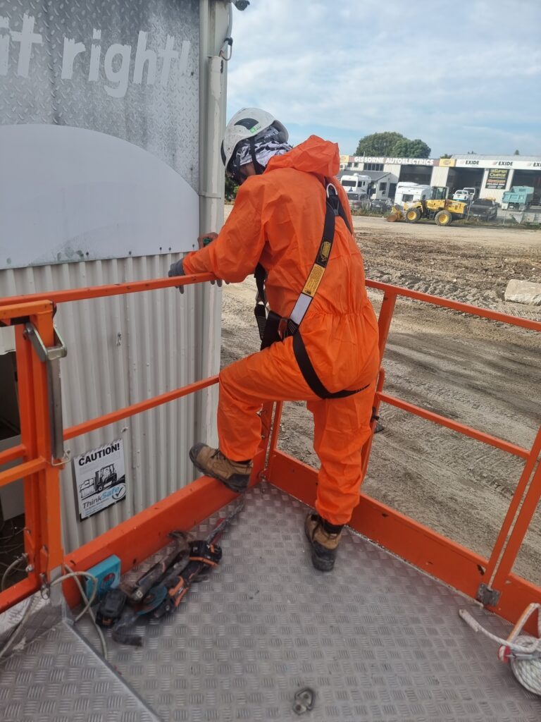Hazard Pro asbestos removal technicians in protective gear on an elevated mobile platform ready to access super6 cladding.