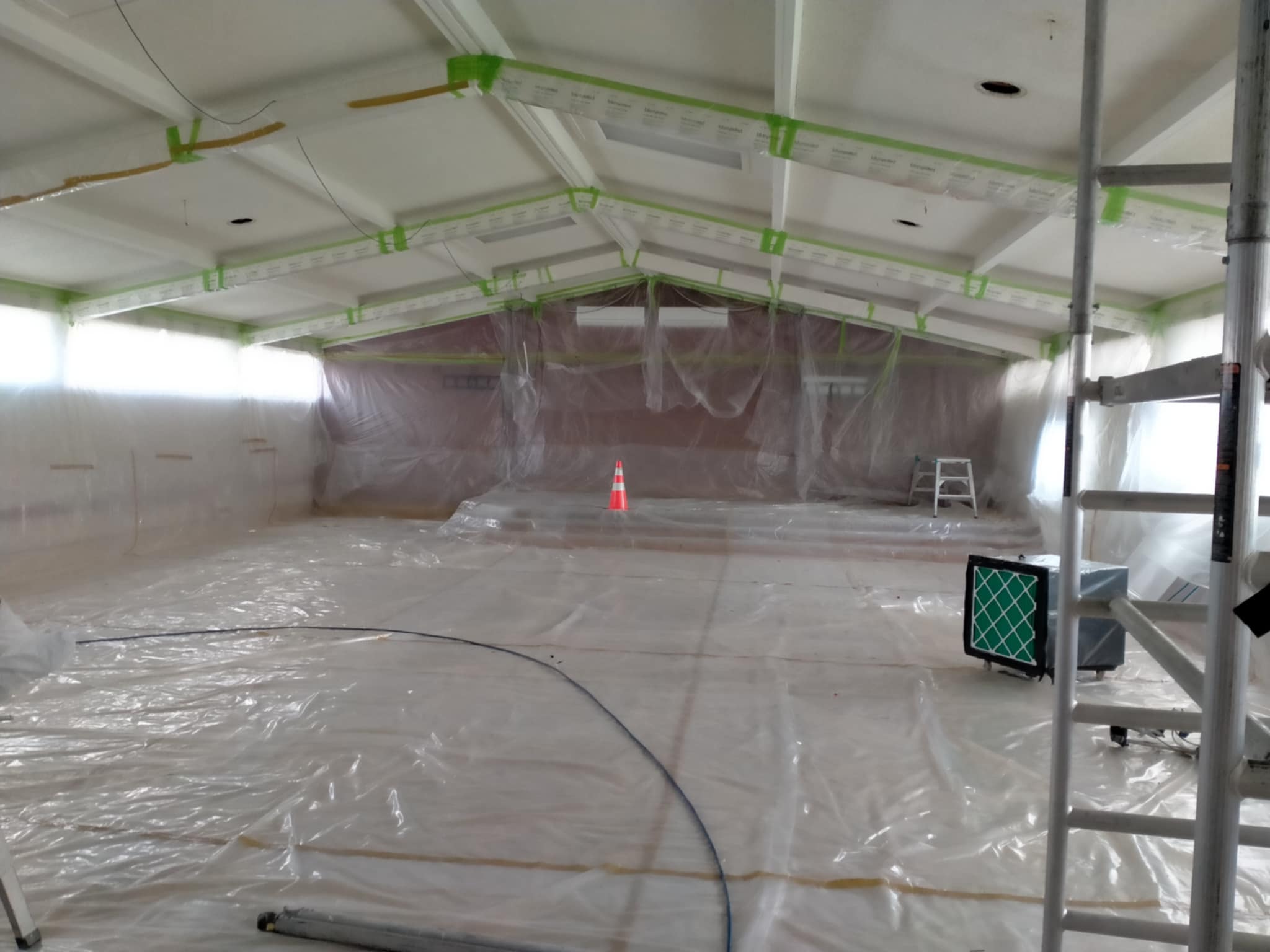 Sealed containment area prepared for ceiling asbestos removal project. along with specialist equipment used to control air flow & dust inside during removal. 