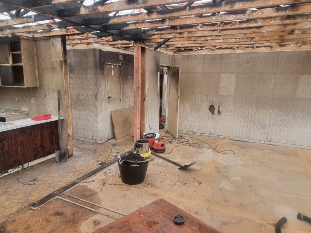 Interior of fire‑damaged demolition site after asbestos vinyl removal and full environmental cleaning by Hazard Pro specialists.