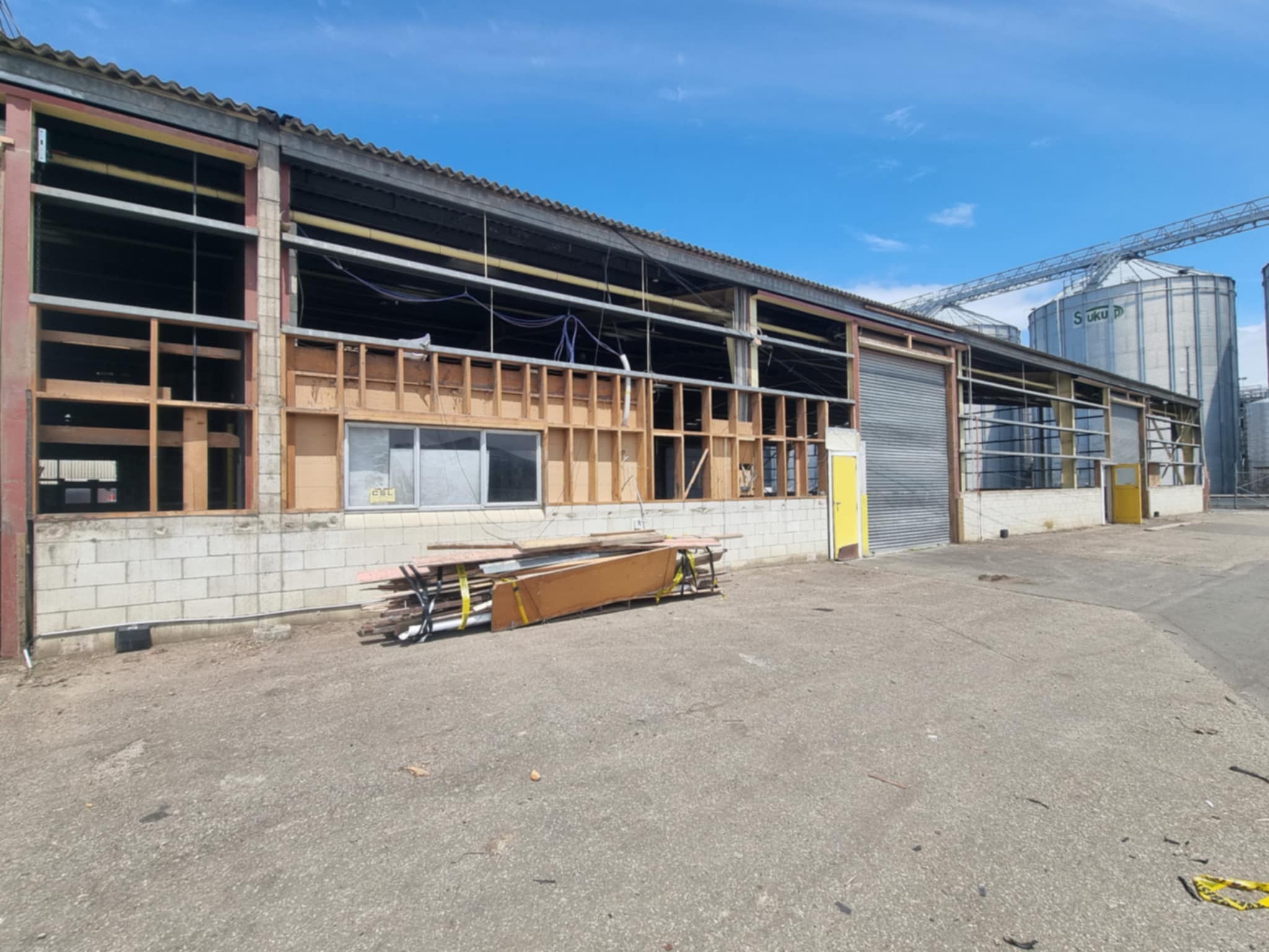 Commercial grain warehouse after removal of asbestos Super6 cladding, with silos visible in the background at a Hazard Pro asbestos removal site.